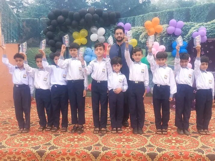 Edutop schoolboys in uniform receiving awards on stage